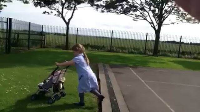 Avie playing with a dolls pushchair
