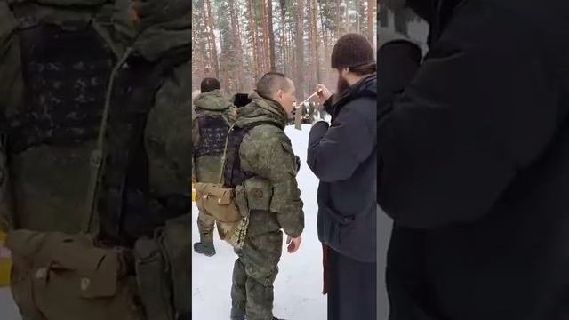 Наши бойцы принимают святое таинство на передовой.