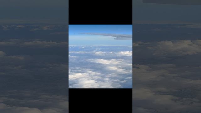 Облака и горы под крылом самолета