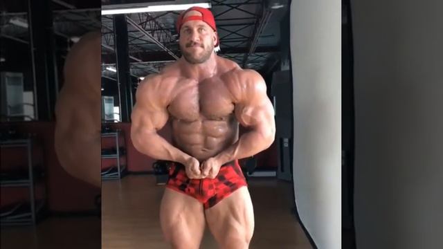 Massive bodybuilder posing and flexing at the gym