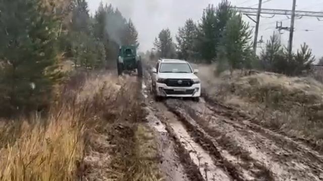 Деревенское бездорожье. Трактор тащит джип.
