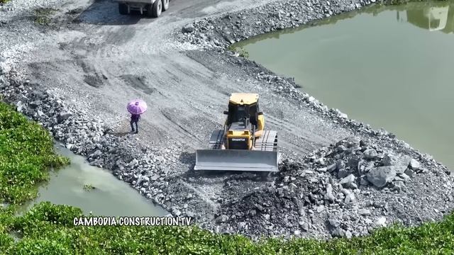 Соединение участков насыпной дороги. Бульдозеры отсыпают дорогу, самосвалы подвозят грунт