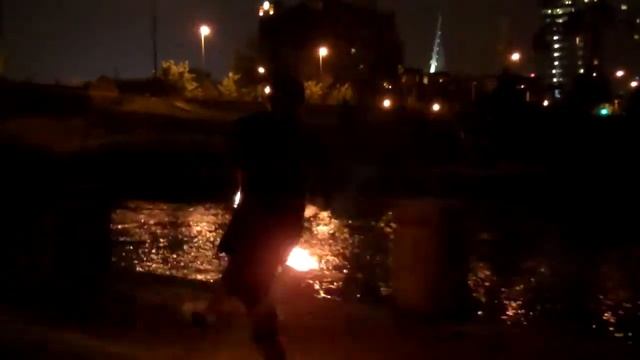 Joe spinning fire Nunchaku at the river