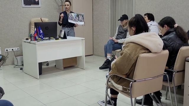 отдел продаж застройщика,  покупатели внимательно изучают предложение.