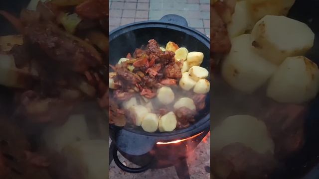 Тушёный картофель с мясом и овощами в казане на костре...