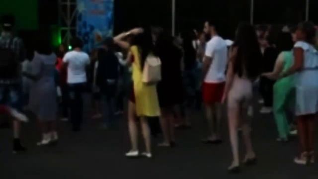 Девушка с рюкзаком прикольно танцует.