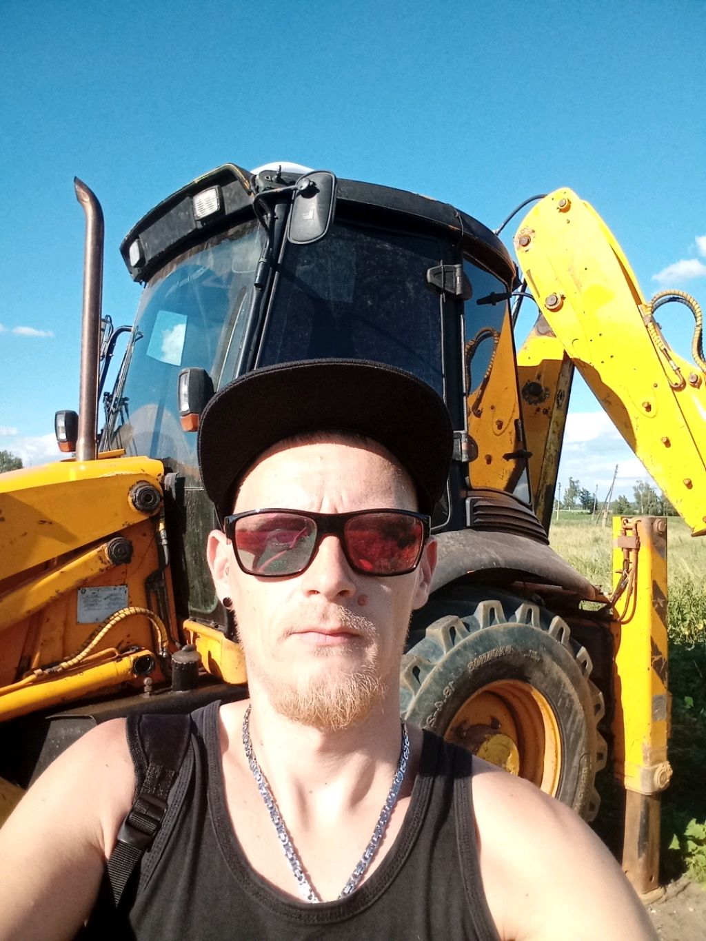экскаватор погрузчик case 580t работает на стройке