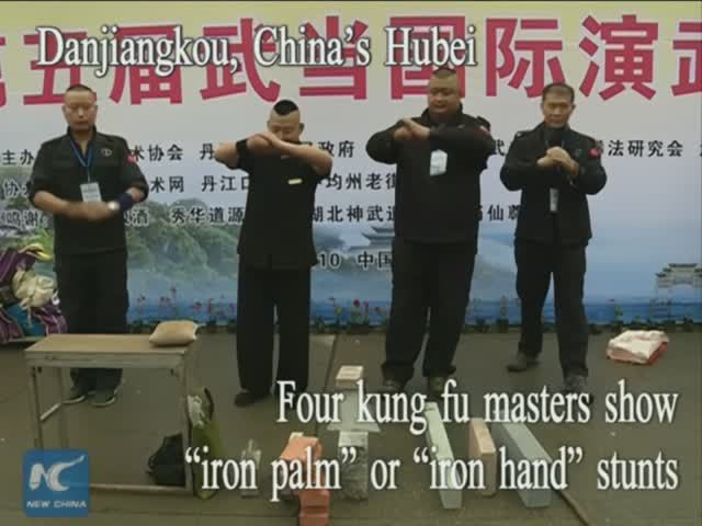 Four kung fu masters show "iron palm" or "iron hand" stunts