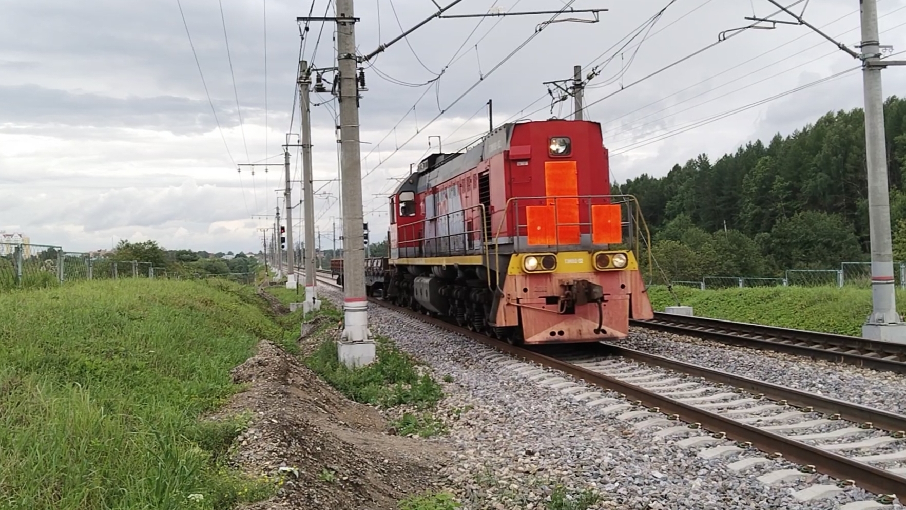 ТЭМ18Д-132 проследует перегон , с двумя вагонами платформами.