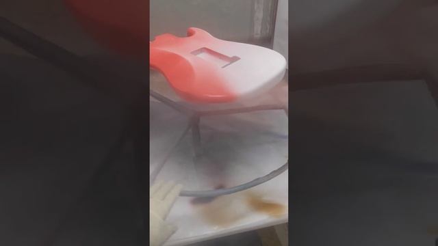 Spraying Fiesta red on a Strat