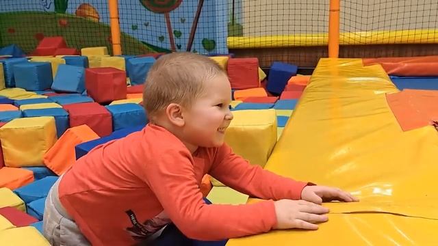 A child on the playground breaks through a wall of bricks and slides down a slide