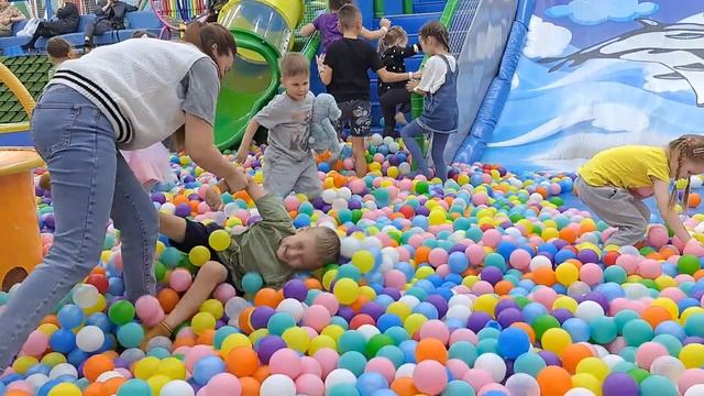 A child slides down a slide on a playground. Playing tag with a child. Running after each other