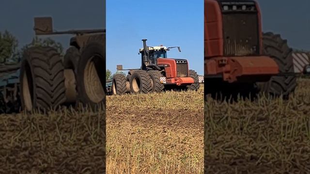 A large tractor plows the land in a field