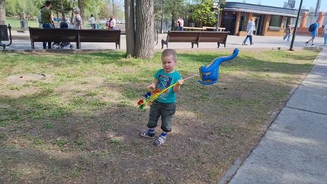 A child plays with an inflatable ball in a park