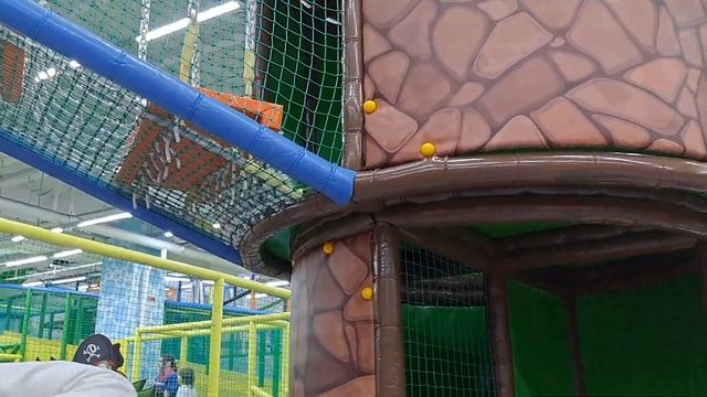 A child is sliding down a slide on a playground. My son and I came to the slide and started playing