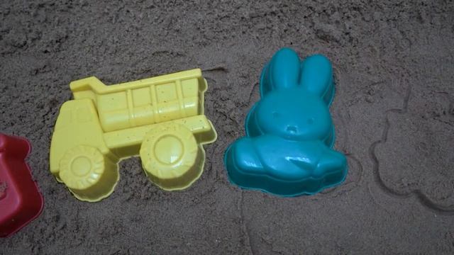 Beach toys crab and starfish in the sandbox are made of sand and are chasing each other