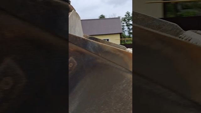 A loader drives with an empty bucket to collect sand