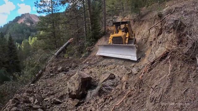 Бульдозер Caterpillar D7G прокладывает путь среди скал