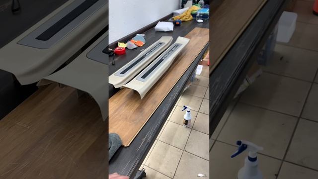 Оклейка порожков в салоне светлого цвета на TLC 300 прозрачной виниловой пленкой.
