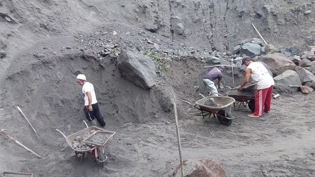 Строительство , шахтёры перекатывают крупные камни упавшие с оползнем
