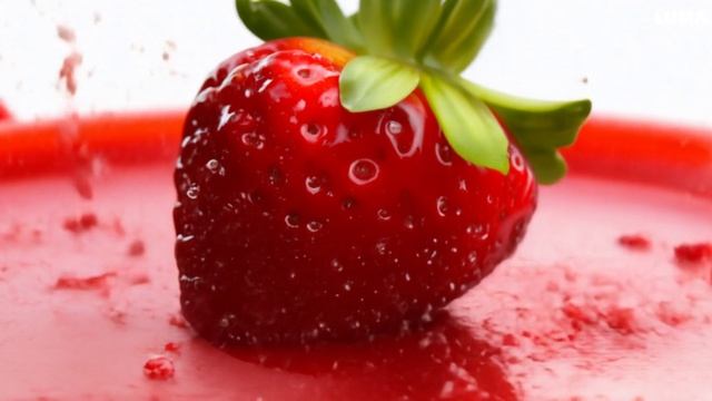 A strawberry berry flies into the screen and splashes on the screen with drops of juice-bcdb18