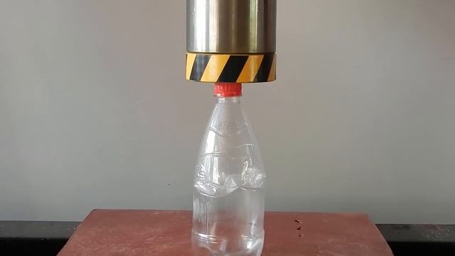 HYDRAULIC PRESS AGAINST EMPTY BOTTLE