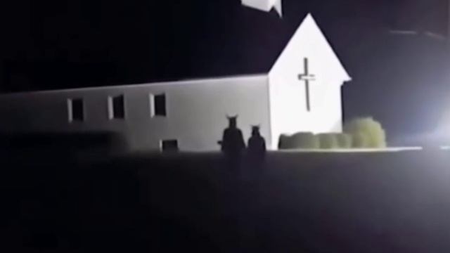 две жуткиефигуры  на фоне католической церкви
