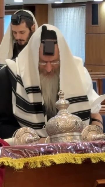 р. Лазар вызван к Торе. На заднем плане проходят уроки Талмуда на иврите и русском.