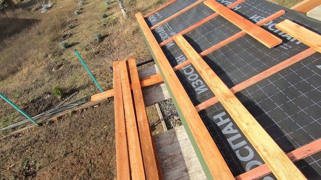 Парень монтирует обрешетку с помощью двух шаблонов. Строительство односкатной крыши своими силам