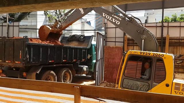 Volvo EC140 carregando caminhão em difícil acesso