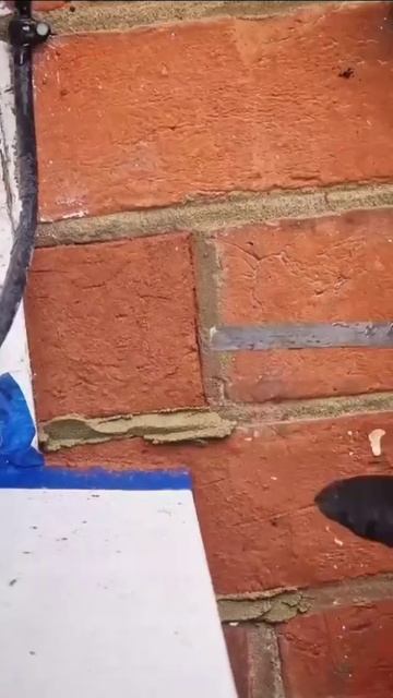 Оконщик ремонтирует кладку после установки новой оконной рамы и подоконника