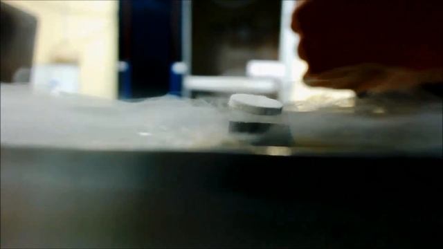 A neodymium magnet levitating above a superconductor cooled by liquid nitrogen.