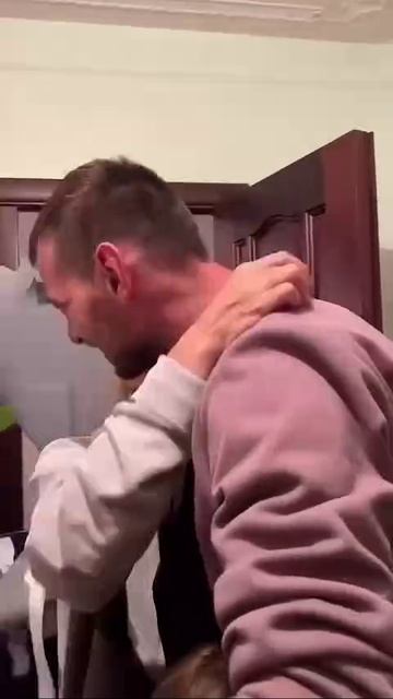 На кадрах боец приехал в отпуск домой. Маленькие дочки бросились к папе в объятия,а супруга военного