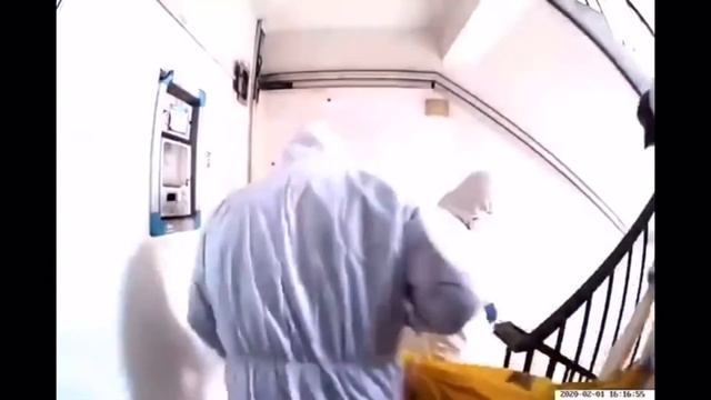 The medical personal carrying a body in a biohazard bag out of an apartment building in China.