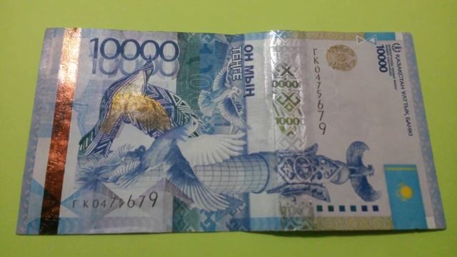 БАНКНОТА 10 000 ТЕНГЕ № серии ГК0475679 на салатовой поверхности Седьмого Марта - ДЕНЕЖНЫЙ ПОТОК
