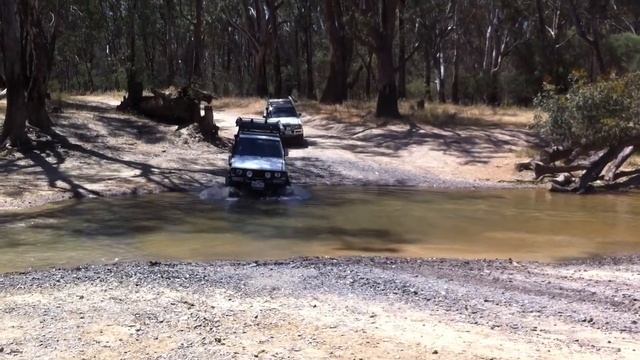 Hilux and Pajero doing river crossing both with 33" big horns