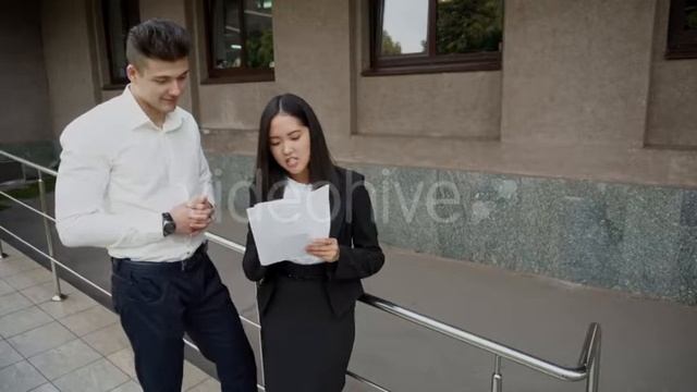 Young Beautiful Asian Business Woman Female and Caucasian Male Look at Documents Talk on Office