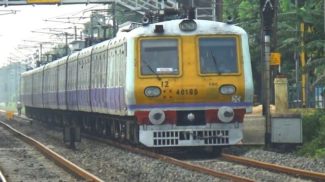 Newly painted Aerodynamic purple color 12 coach EMU local train crossing busy rail gate