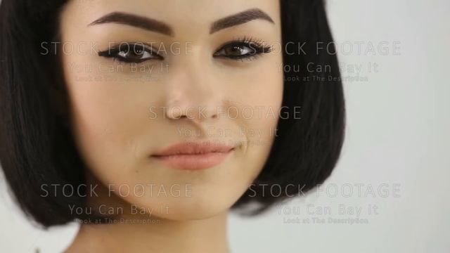 Smiling girl with Cleopatra's make-up and haircut looking at camera