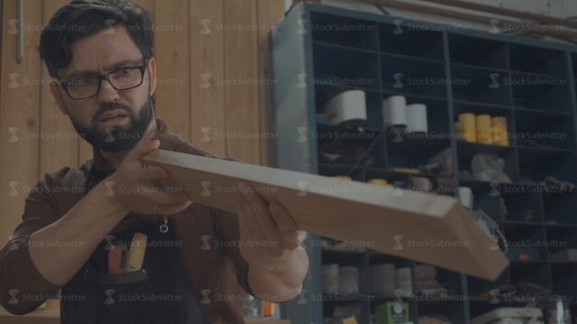 Carpenter examines the workpiece, checks the quality of the woodwork