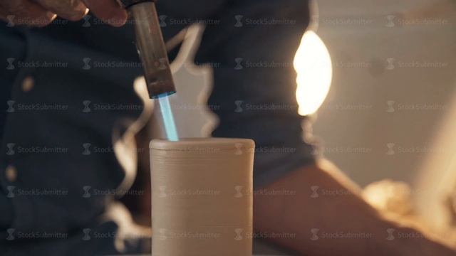 Clay figure in the shape of a tube on a dark background close up