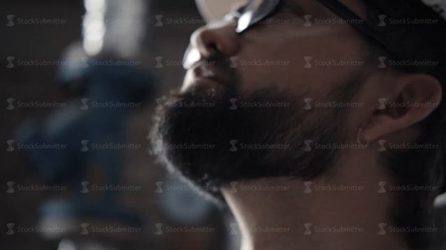 Profile of man in helmet, glasses: he looks down at the sheet of notes