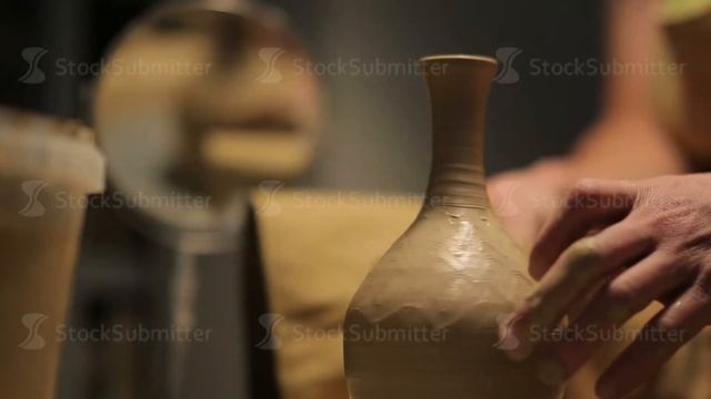 hands of a potter, creating an earthen jar on the circle