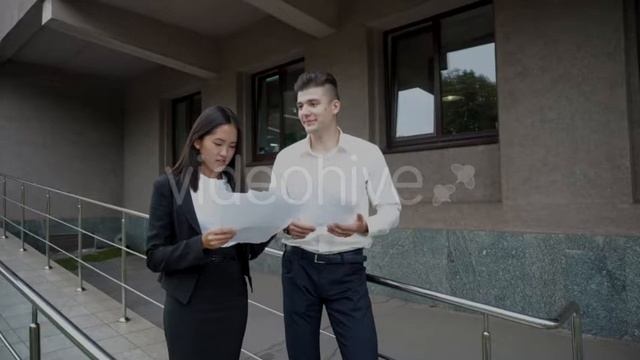 Young Beautiful Asian Business Woman Female and Caucasian Male Look at Documents Talk on Office