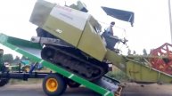 Claas rice(Paddy) harvesting machine is easily loaded in tractor tipping trolley without ram