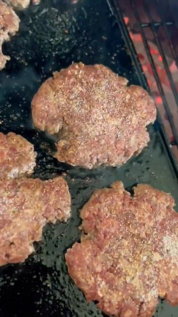 Smashburgers waiting to be flipped 🍔 using the Big Green Egg cast iron plancha griddle 🔥