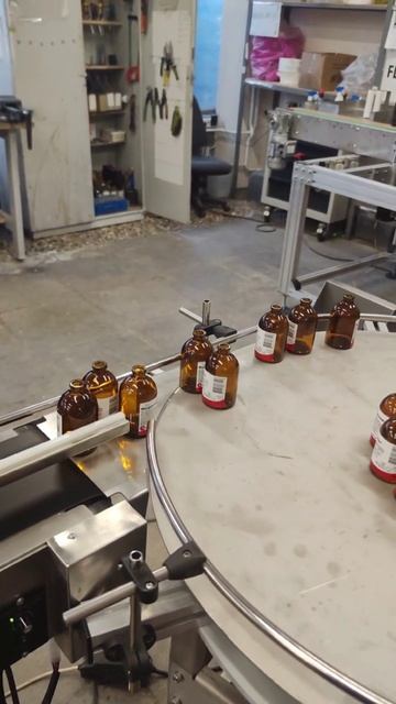 Беспрерывная работа производства. Этикетировочный автомат нанесения этикеток на стеклянные флаконы