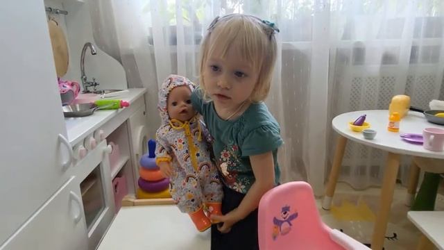 Катя  собирает baby born на прогулку.