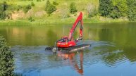 Понтонный экскаватор, оснащенный землесосом плывет по воде