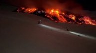 Лыжники катаются по свежему снегу на вулкане Этна, склоны которого покрыты лавой